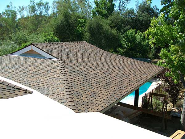 new architectural asphalt roof shingle installation in front of pool