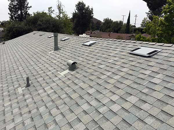 new light gray asphalt roof shingle installation around skylights
