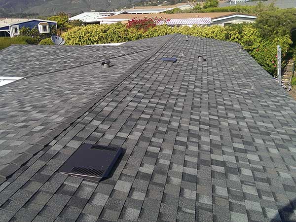 new dark gray asphalt roof shingle installation around skylights