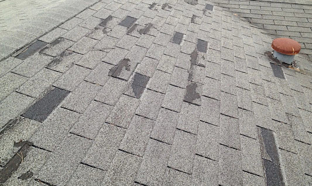 a damaged roof missing asphalt shingles